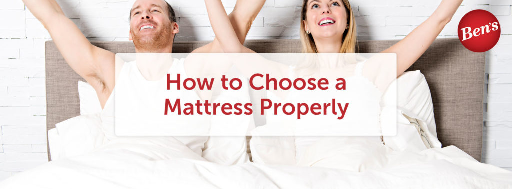 People sitting in bed on a mattress with their hands in the air.